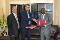 The Minister Paul Koffi Koffi and the IIPE-UNESCO Dakar Coordinator Guillaume Husson exchange copies of the signed agreement, with Naceur Chraïti, Head of PEFOP